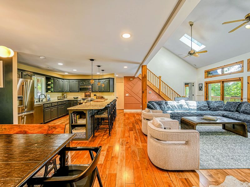 Open Layout - The kitchen and island flow into the living area under a vaulted, skylit ceiling.