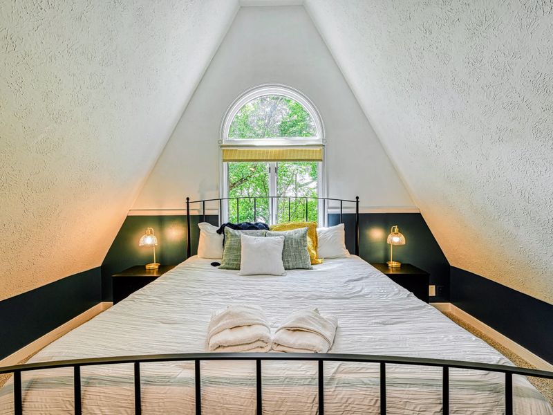 Under the Arch - An arched window crowns the king bed beneath a dramatic vaulted A-frame ceiling.