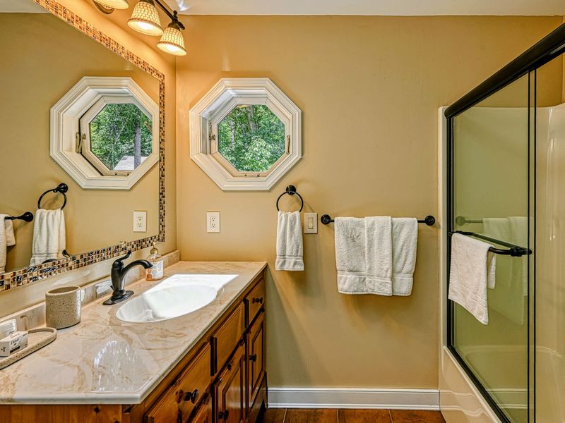 Bath Detail - Octagonal windows and mosaic tile add character to this bright upper-level bath.
