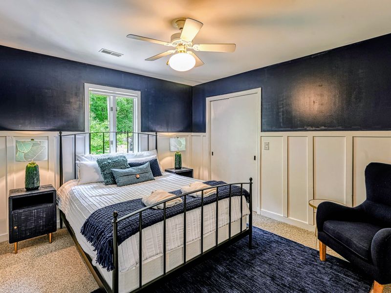 Bedroom 2 - A bright, comfortable queen room with an accent chair and plenty of closet space.