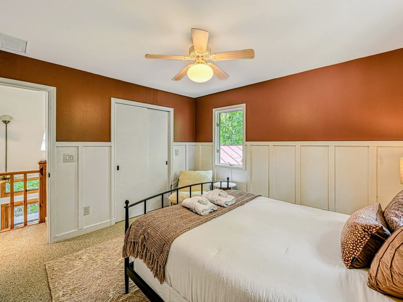 Bedroom 3 - A queen room with a cozy corner chair and a leafy window, just off the upstairs landing.