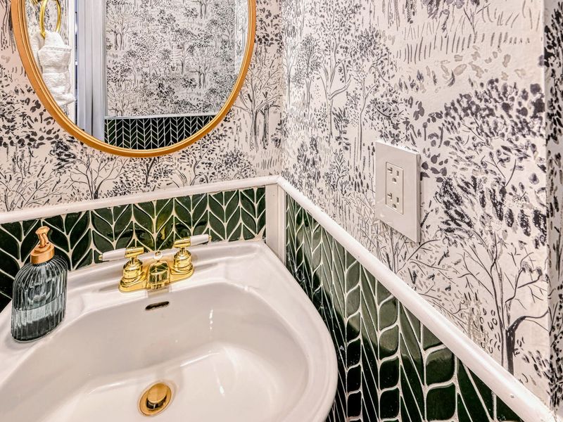 Half Bath Detail - Gold fixtures and a round mirror finish the powder room with a playful touch.