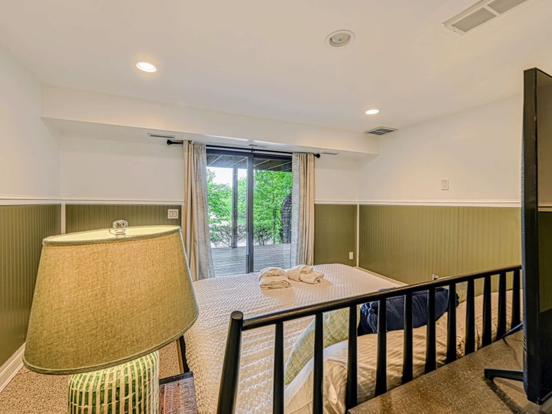 Walkout Access - Sliding doors open to the patio, filling the lower level with natural light and woodland views.