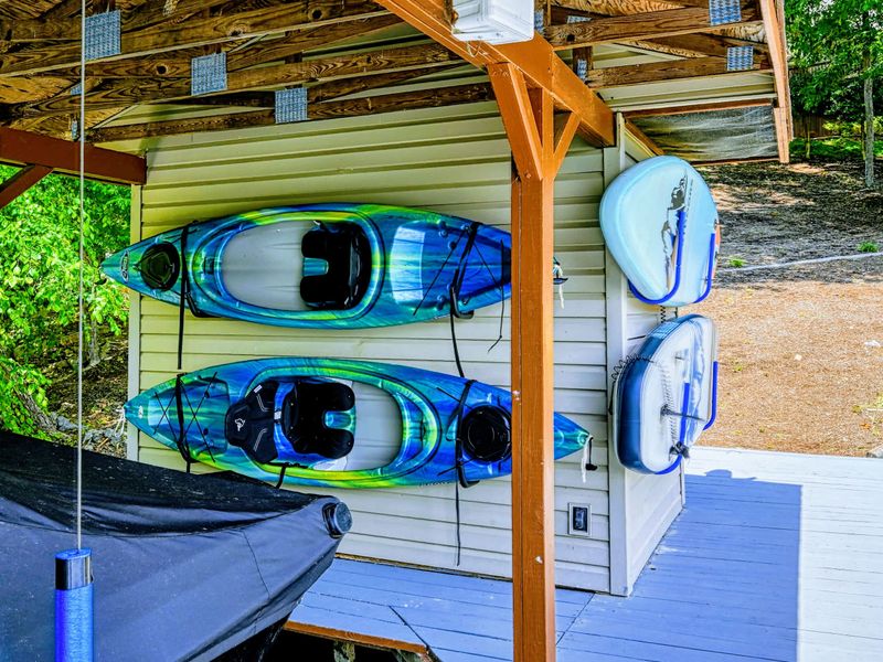 Kayaks and Paddleboards - Two kayaks and two paddleboards stored on the boathouse, ready for a loop around the cove.