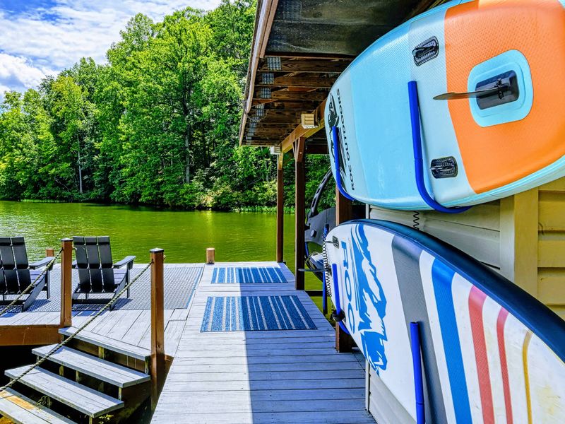 Water Toys - Paddleboards line the boathouse beside the dock, ready for a lazy paddle around the calm cove.