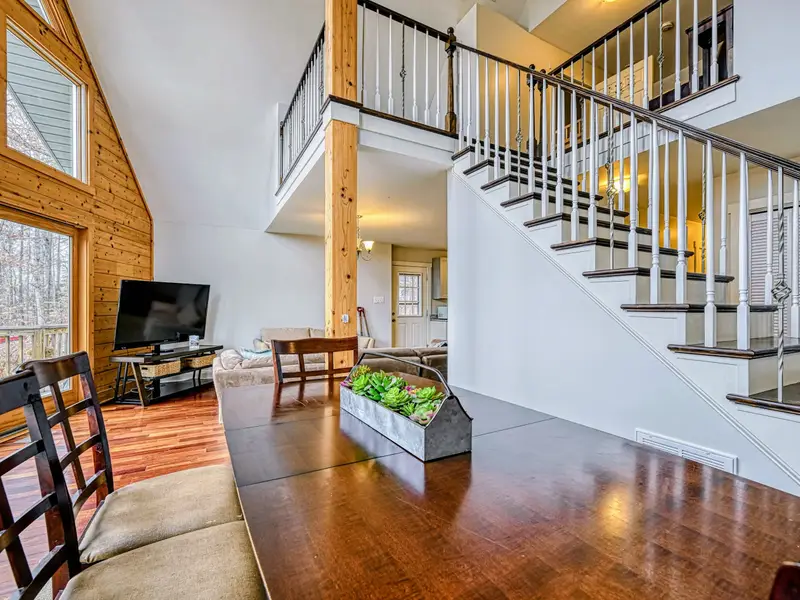 Great Room - The dramatic A-frame window wall floods the home with light and frames the trees beyond.