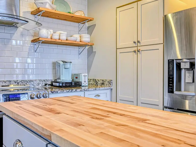 Kitchen - Full-size stainless fridge and generous prep space make hosting a crowd simple.