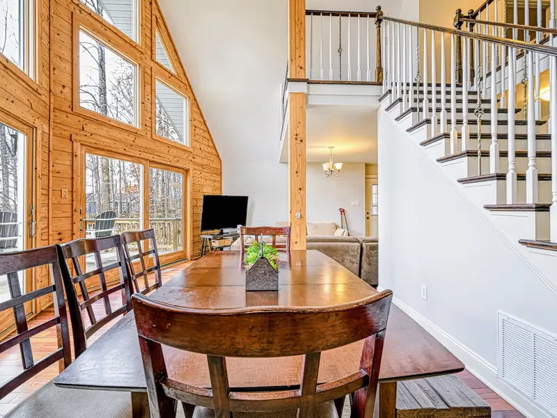 Dining Area - A round table beneath the A-frame windows, lake light pouring in over breakfast.