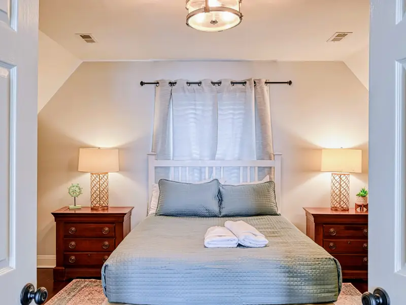 Primary Suite - Vaulted ceilings and soft linens make this upstairs retreat a restful escape.