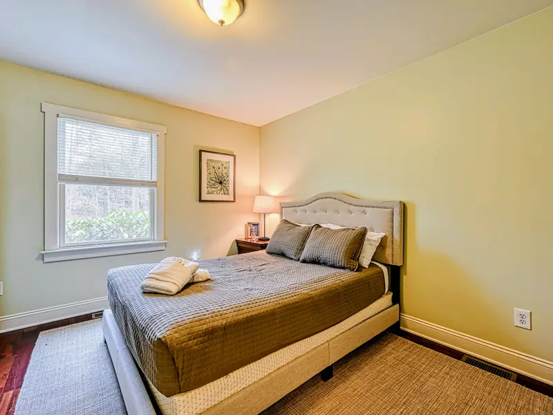 Bedroom 3 - A cozy main-level queen with warm light and comfortable bedding.