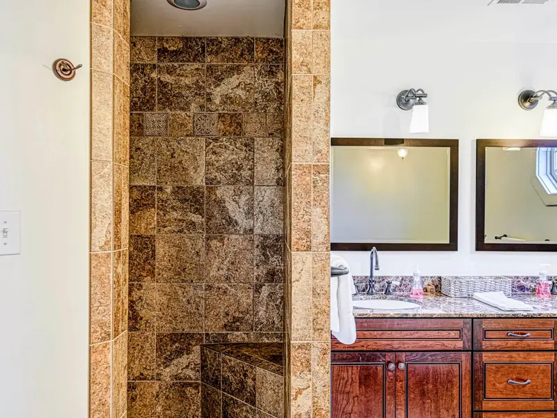 Bathroom - A walk-in shower with a striking wood-accent wall adds character to the space.