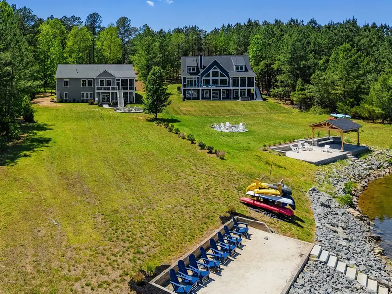 Bird's-Eye View - Acres of green lawn, a stone fire pit, lakeside pavilion, and dock frame the home's private stretch of Lake Anna shoreline.