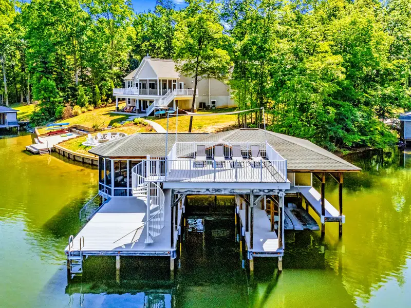 Boathouse - Loungers on the upper deck catch the afternoon sun while the home sits just up the gentle slope behind.