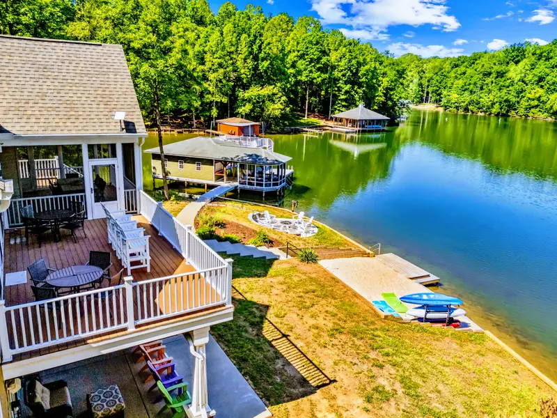 Upper Deck - The view from up top runs across the backyard to the fire pit, beach, and dock, with the lake beyond.
