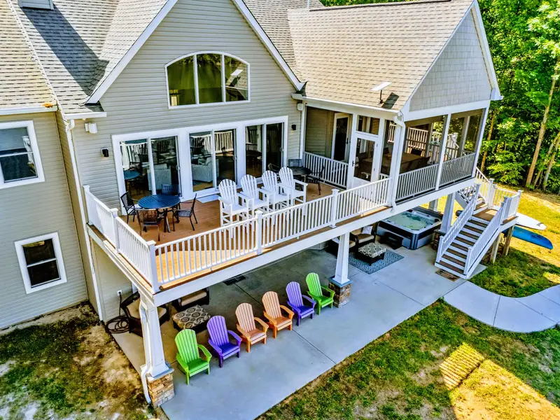 Rear Exterior - Dining on the main deck, a hot tub off to the side, and lake views from nearly every seat.