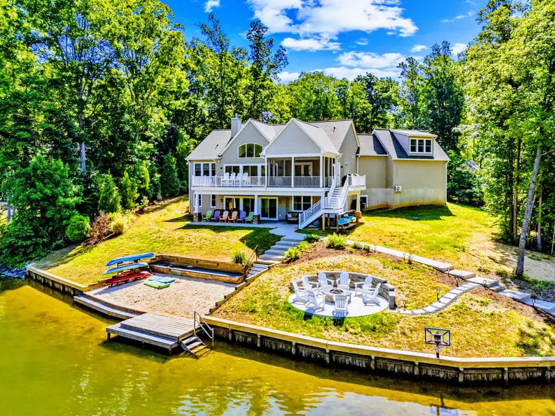 Backyard - Terraced lawn links the decks to a fire pit circle and sandy beach below, so the whole group spreads out toward the water.