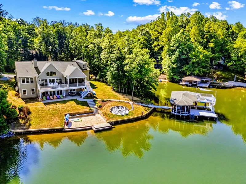 Aerial View - Looking back from the water to the home, fire pit circle, and dock on a quiet, protected cove.