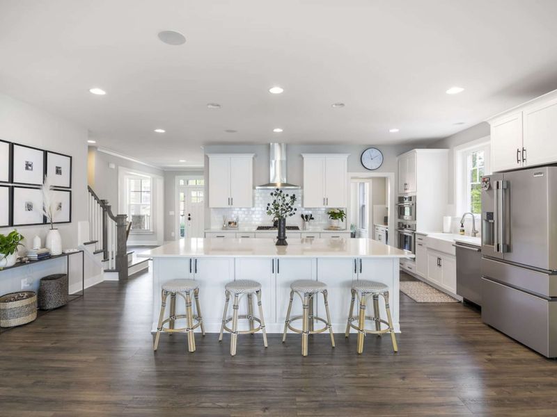 Large fully stocked kitchen with huge island, new stainless steel appliances, and large walk-in pantry.
