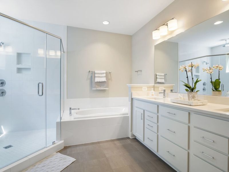 Massive Primary Suite bathroom with a huge shower that has regular and rain showerheads and a tub for relaxing.