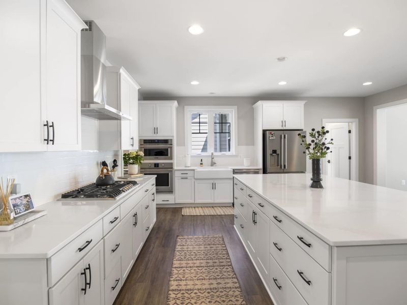 Large fully stocked kitchen with huge island, new stainless steel appliances, and large walk-in pantry.