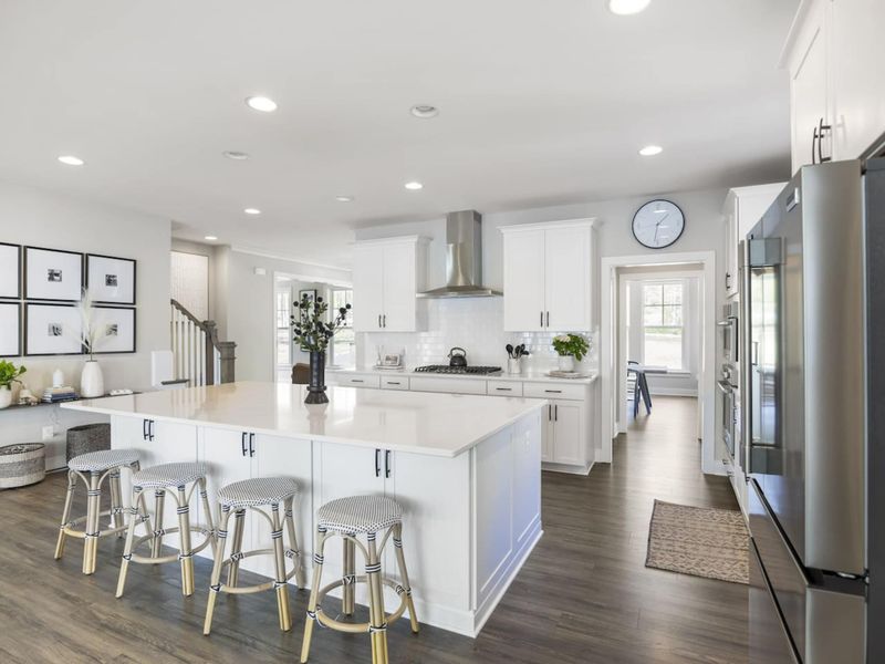 Large fully stocked kitchen with huge island, new stainless steel appliances, and large walk-in pantry.
