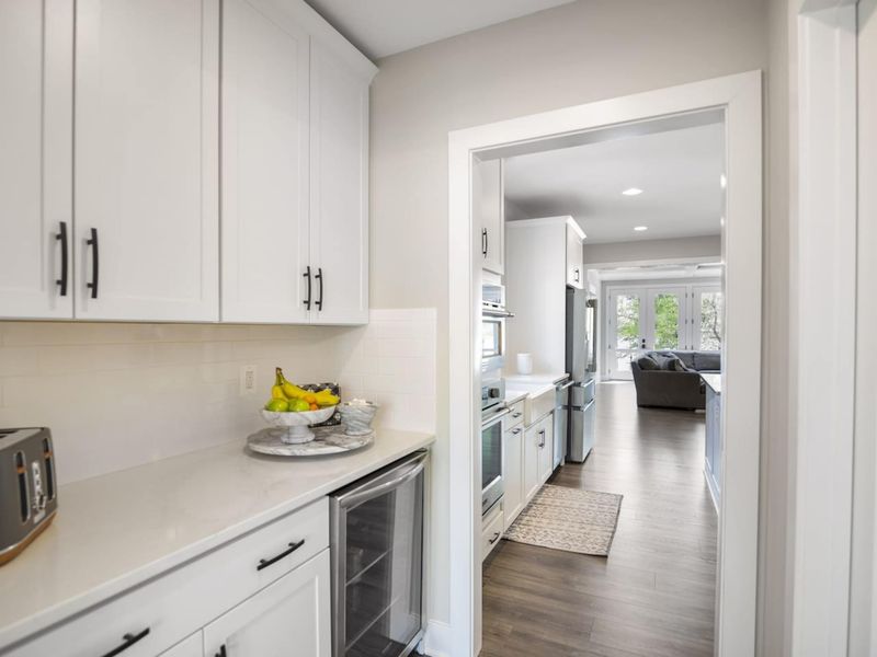 Large fully stocked kitchen with huge island, new stainless steel appliances, and large walk-in pantry.