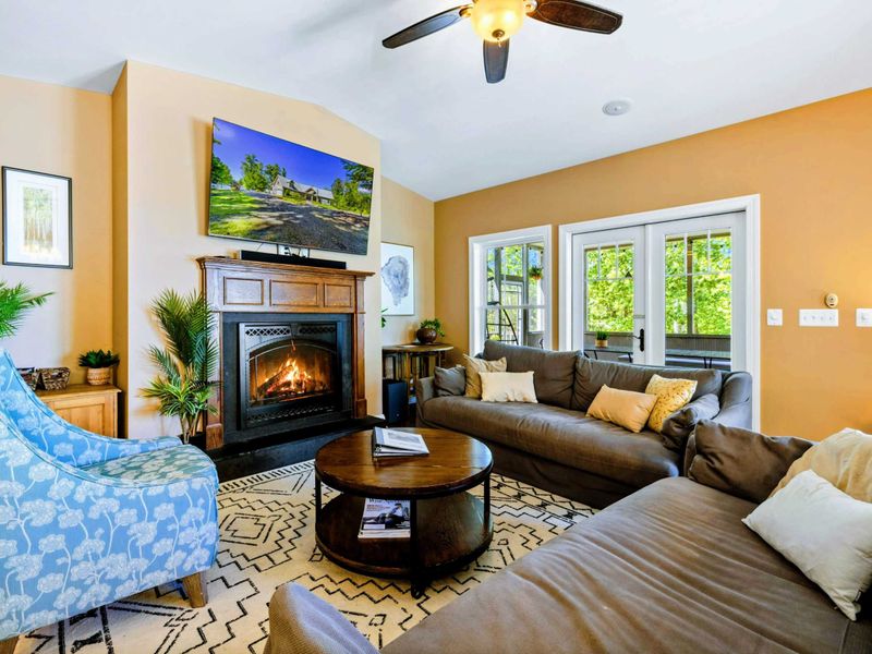 Open living room with amazing water views, comfy couches, Smart TV, and fireplace.