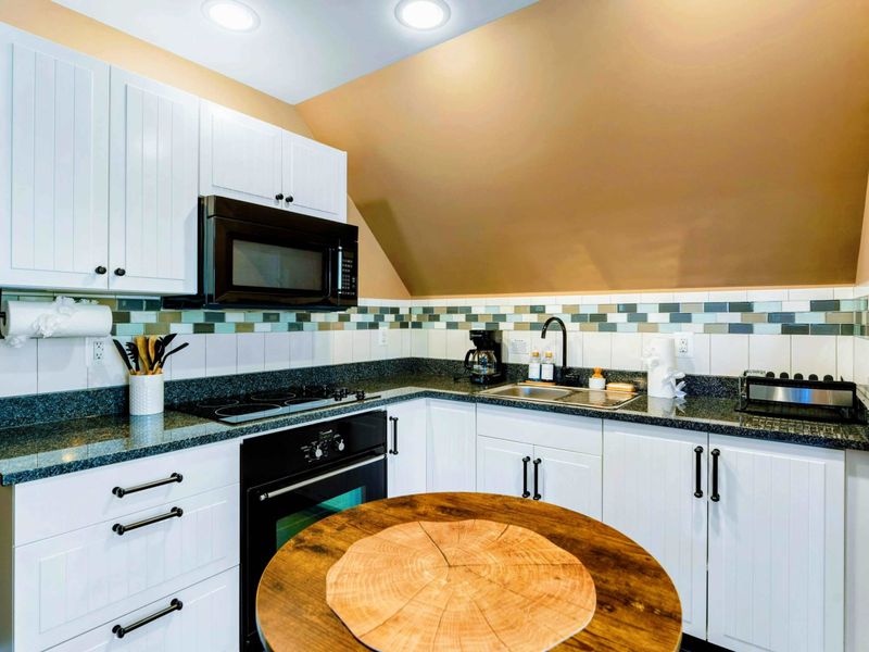 Large upper level suite with queen bed, fully stocked kitchen, desk, and bathroom.