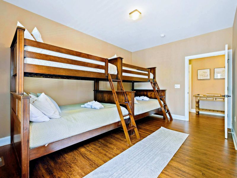 Main level double bunk bed room with two double beds and two twin beds, and a shared bathroom.