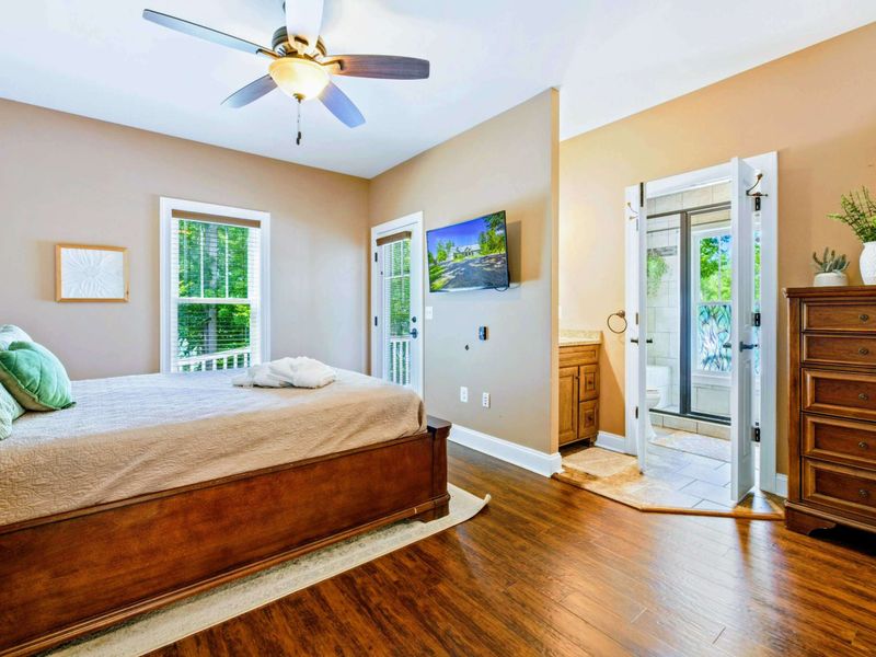 Main level bedroom with queen bed, deck access and shared bathroom.