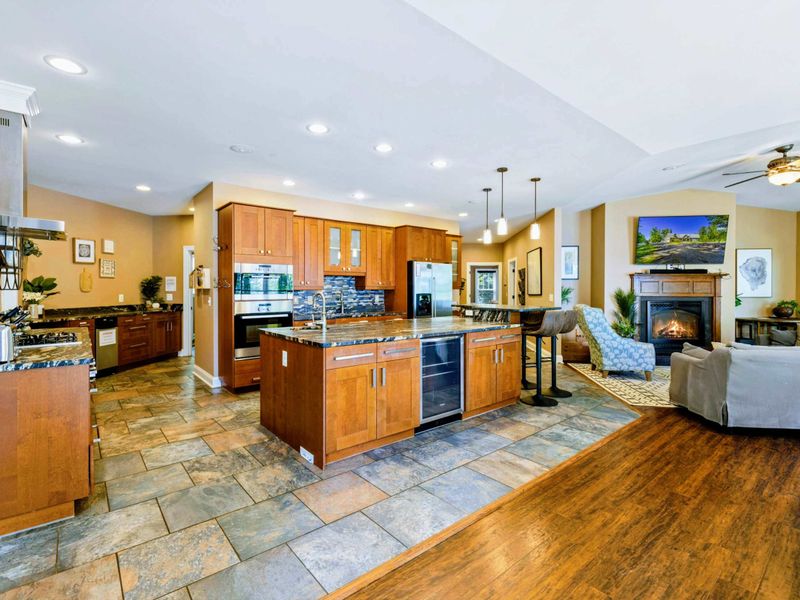 Large fully stocked main kitchen with huge island, and stainless steel appliances.