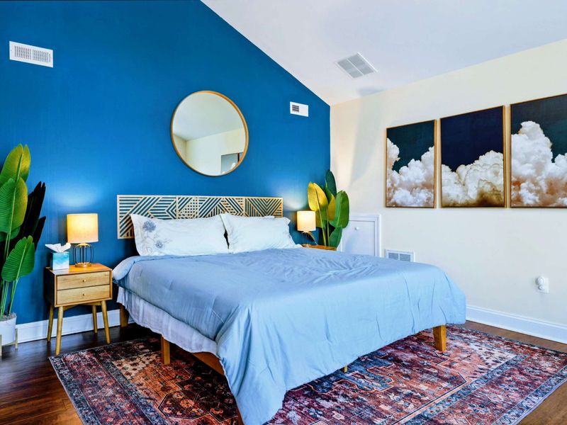 Large upper level primary suite with queen bed, balcony, fireplace, private TV area, and bathroom.