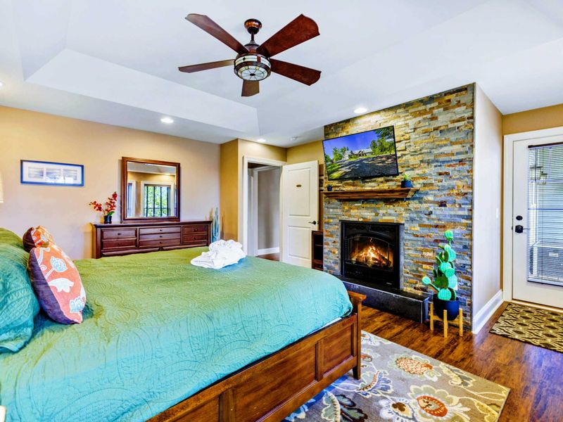 Suite with king bed, fireplace, TV, and jetted tub.