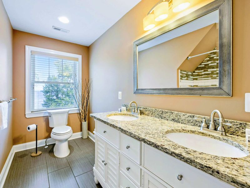 Large upper level primary suite bathroom complete with his and hers sinks.