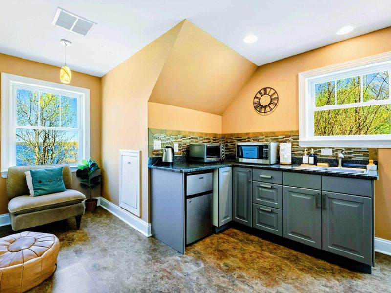 Large upper level primary suite with queen bed, balcony, fireplace, private TV area, and bathroom.