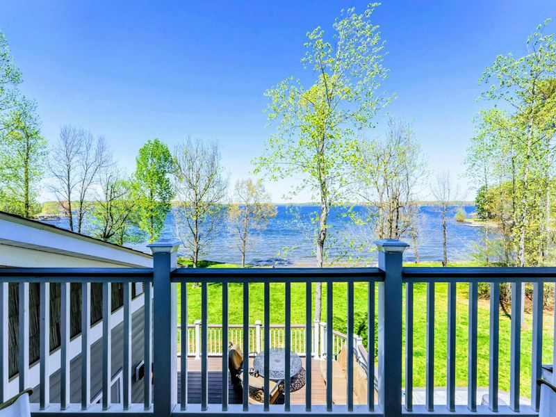 Large upper level primary suite with queen bed, balcony, fireplace, private TV area, and bathroom.