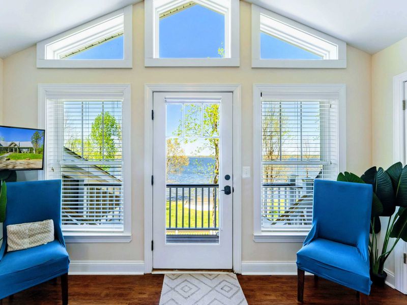 Large upper level primary suite with queen bed, balcony, fireplace, private TV area, and bathroom.