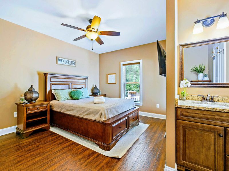 Main level bedroom with queen bed, deck access and shared bathroom.