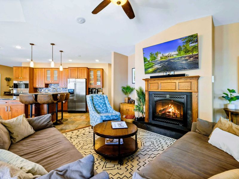 Open living room with amazing water views, comfy couches, Smart TV, and fireplace.