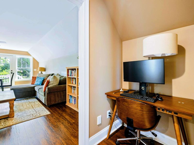 Large upper level primary suite with queen bed, balcony, fireplace, private TV area, and bathroom.