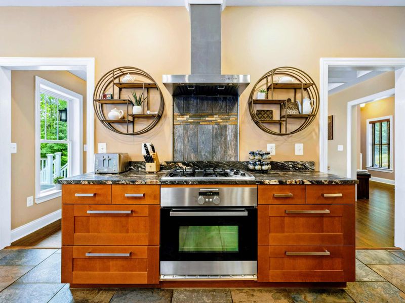Large fully stocked main kitchen with huge island, and stainless steel appliances.