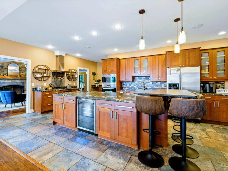 Large fully stocked main kitchen with huge island, and stainless steel appliances.