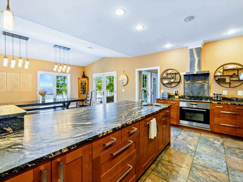 Large fully stocked main kitchen with huge island, and stainless steel appliances.