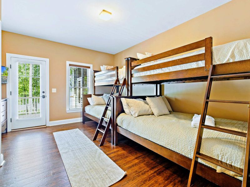 Main level double bunk bed room with two double beds and two twin beds, and a shared bathroom.
