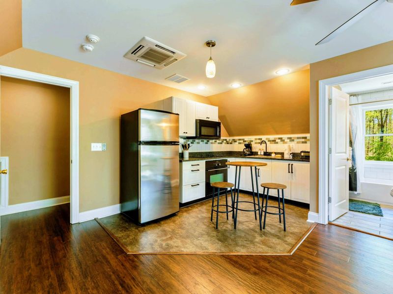 Large upper level suite with queen bed, fully stocked kitchen, desk, and bathroom.