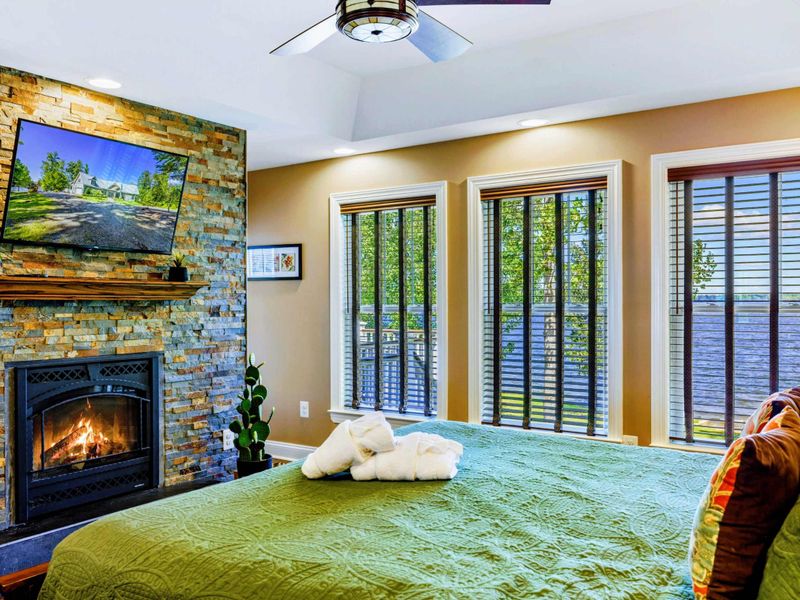 Suite with king bed, fireplace, TV, and jetted tub.
