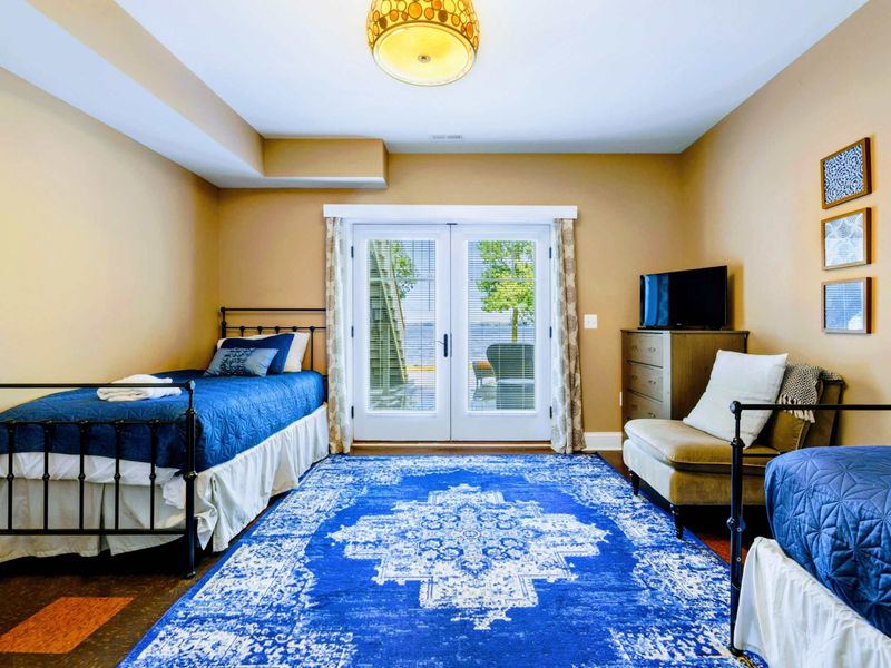 Lower level bedroom with two twin beds and a walkout patio.