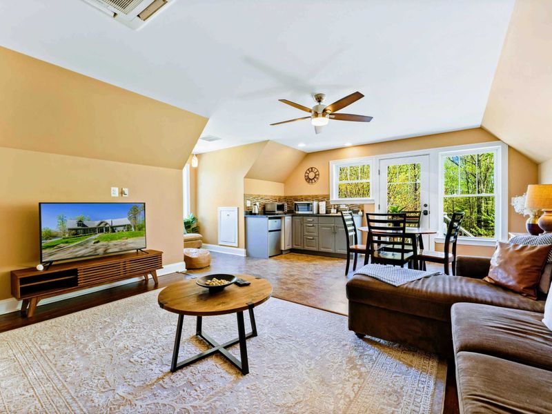 Large upper level primary suite with queen bed, balcony, fireplace, private TV area, and bathroom.