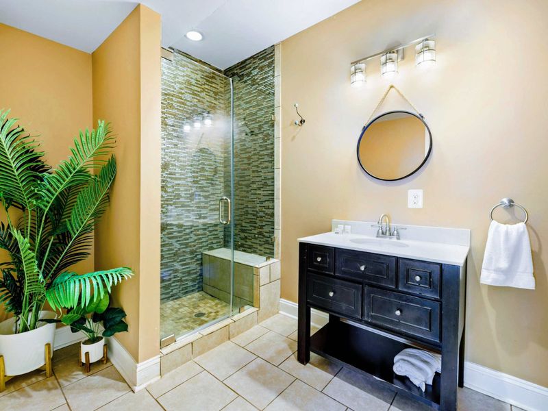 Suite with queen bed, bathroom, and walkout patio.