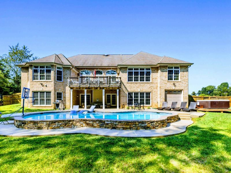 Backyard - The full property from the lawn: stone-and-stucco home, pool, hot tub, and fenced yard on 2.63 private acres.